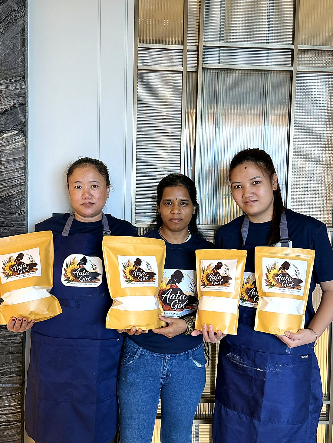 The Aata Girl team holding packed bags